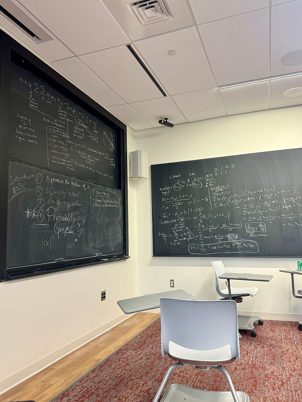 Classroom chalkboards filled with portfolio optimization, QUBO, Ising-model, and noise-model calculations