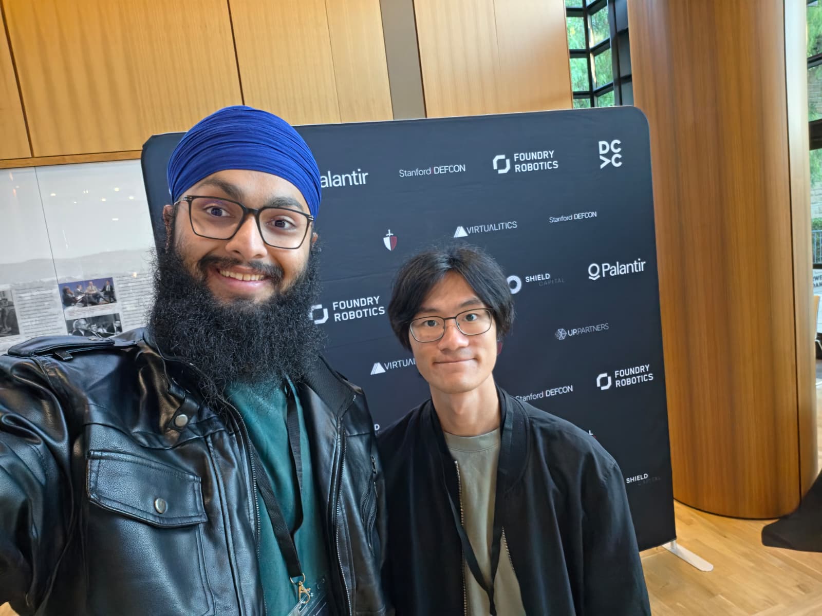 Tanish Singh Rajpal with Supavit Pitaknarongphorn at the Stanford DEFCON photo wall